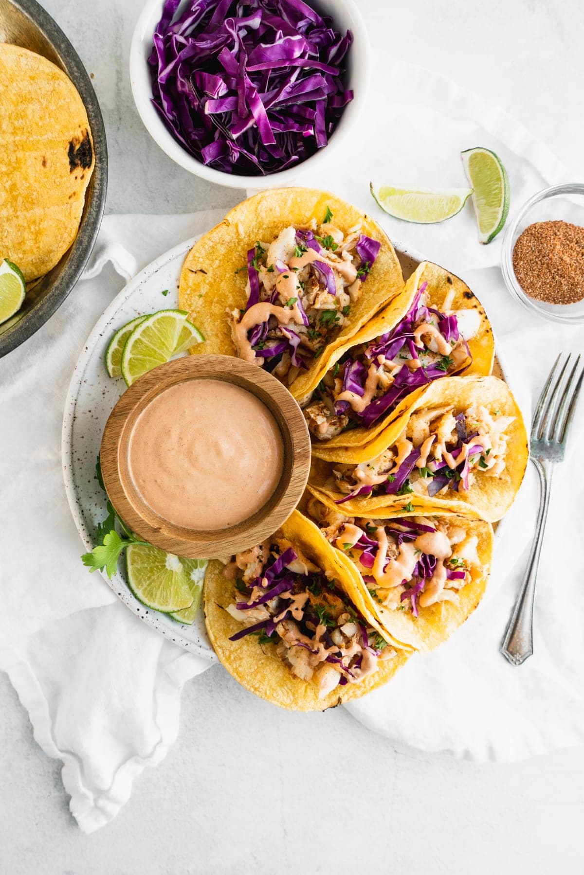 fish tacos on a white round plate with chipotle mayo