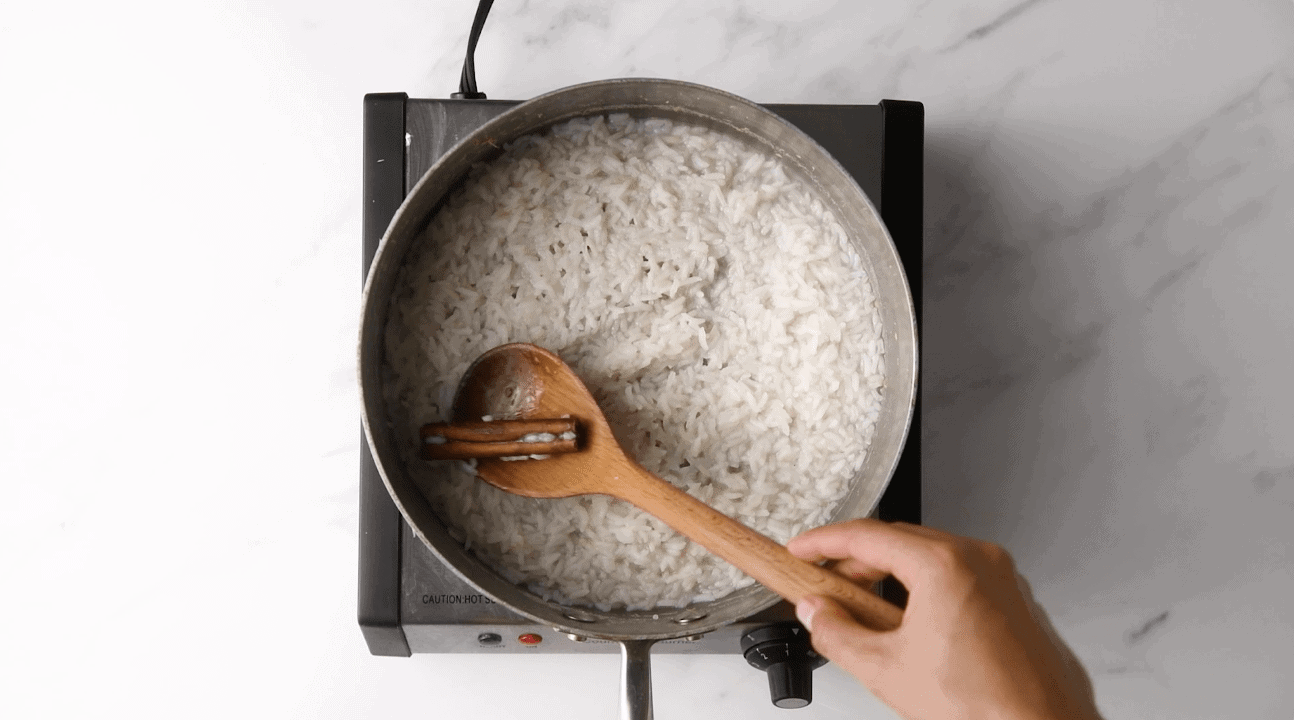 making arroz con leche on the stove with rice and cinnamon
