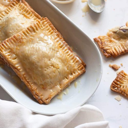 Super easy, semi-homemade guava and cream cheese pop tarts made using refrigerated pie crust then topped with a drizzle of condensed milk. The perfect combination of a Cuban treat on an American classic.