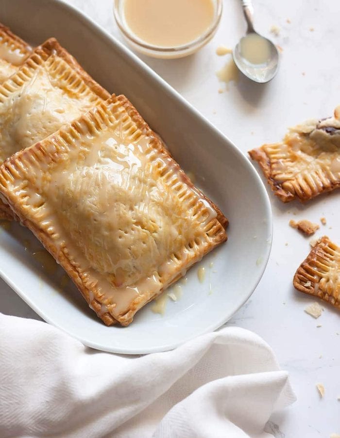 Super easy, semi-homemade guava and cream cheese pop tarts made using refrigerated pie crust then topped with a drizzle of condensed milk. The perfect combination of a Cuban treat on an American classic.