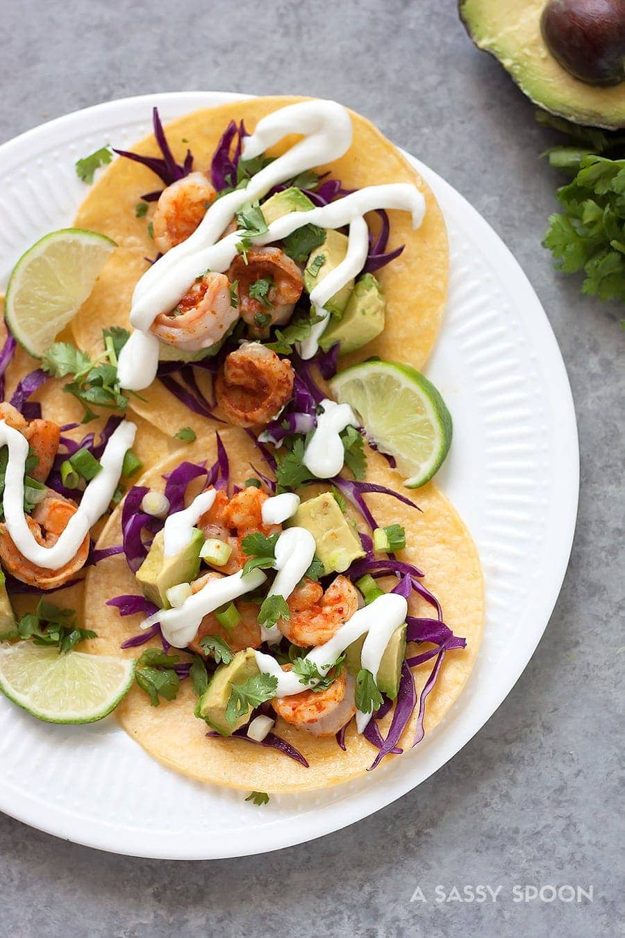 Tacos with shrimp marinated in tequila, lime juice, cumin, chili powder and topped with red cabbage, avocado, cilantro and a drizzle of sour cream!