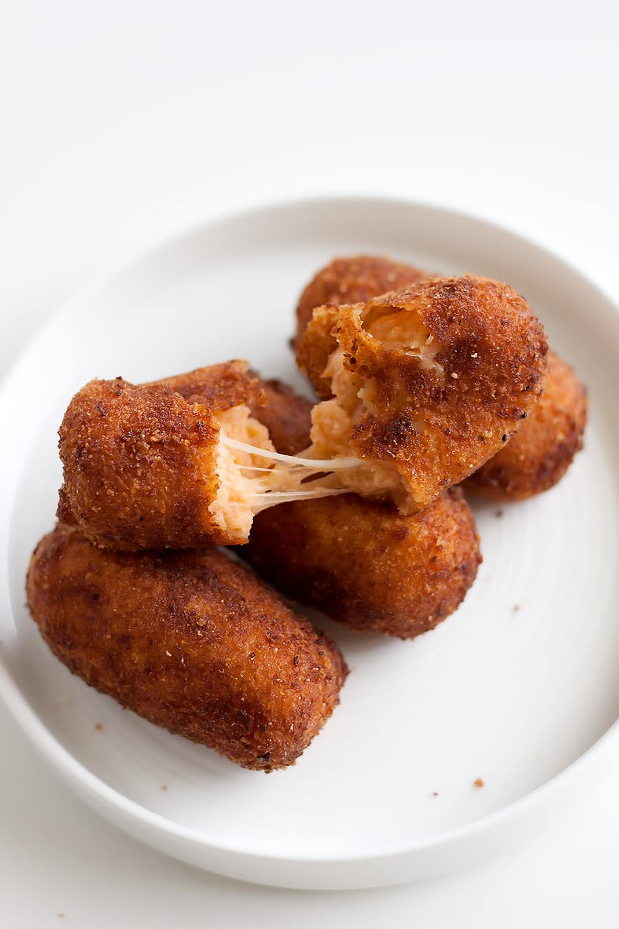 Turn pizza into a croqueta! Bite-sized, crispy logs filled with mozzarella, tomato, and spices. Small bites with BIG pizza flavors.