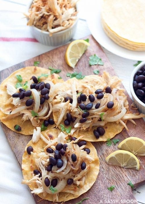 Using leftovers or shredded rotisserie chicken, make these Crispy Chicken Tacos, vaca frita style, topped with sautéed onions and black beans!