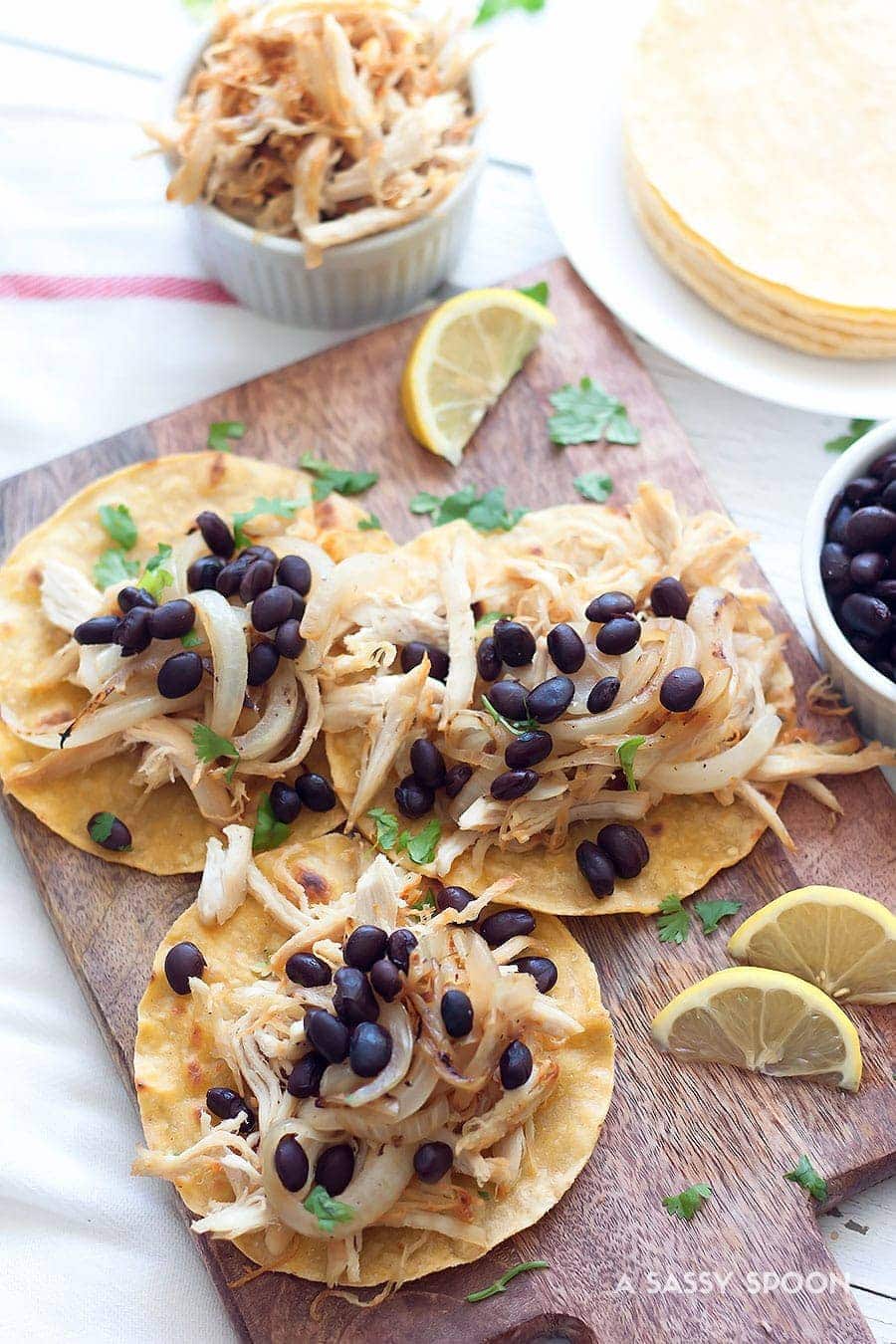 Using leftovers or shredded rotisserie chicken, make these Crispy Chicken Tacos, vaca frita style, topped with sautéed onions and black beans!