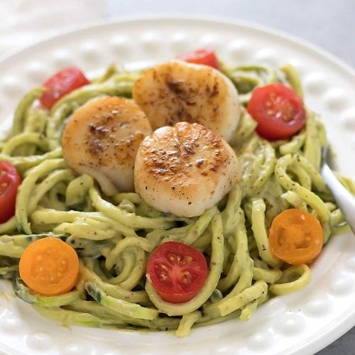 Zucchini noodles topped with a avocado sauce and seared scallops