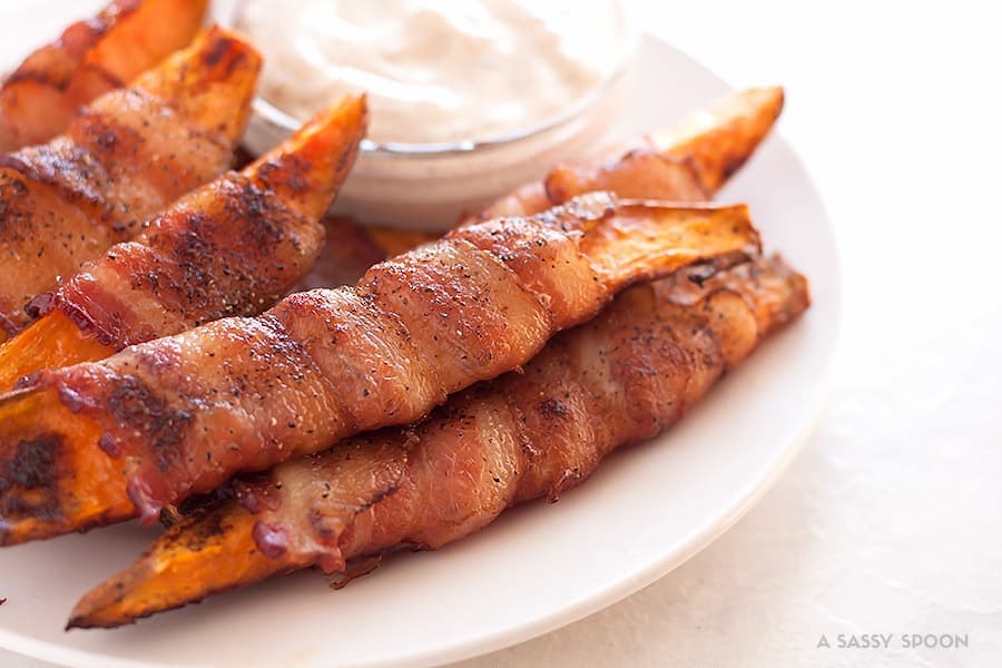 Sweet potatoes cut into fries, seasoned with salt, pepper, and smoked paprika then wrapped in bacon and baked to perfection. Best appetizer everrr!