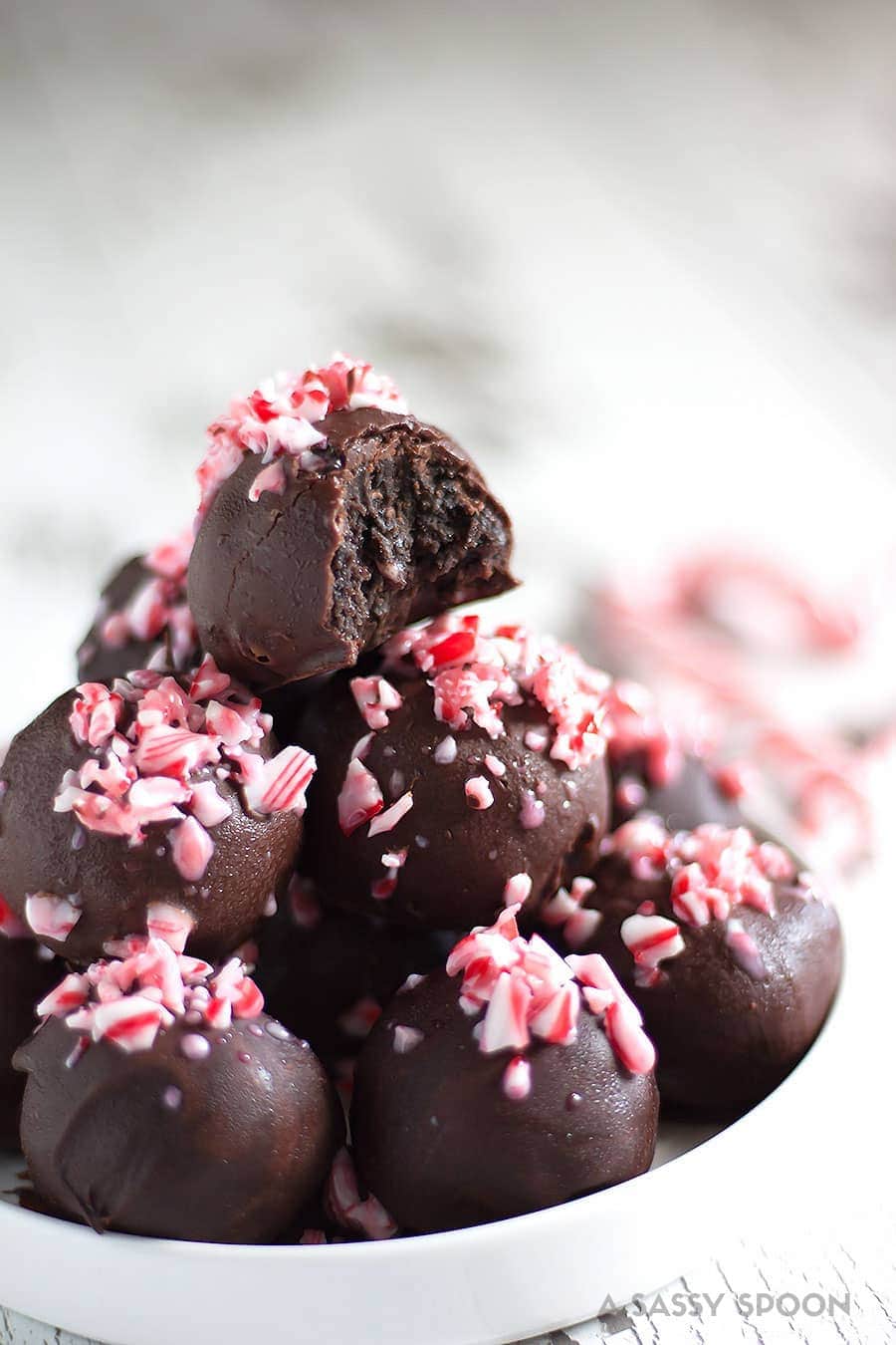 Crushed candy canes, crushed Oreo cookies, cream cheese, and melted dark chocolate result in the easiest, most refreshing, and festive dessert ever - Chocolate Peppermint Oreo Truffles!