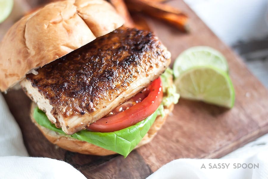 Blackened mahi-mahi sandwich on a kaiser roll with lettuce, tomato and mashed avocado