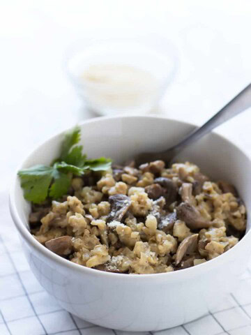 Cauliflower mushroom risotto served in white bowl
