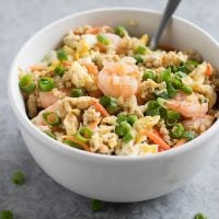 Forget takeout. Make Cauliflower Shrimp Fried Rice at home using riced cauliflower, carrots, peas, onions, garlic, and coconut aminos in just 15 minutes!