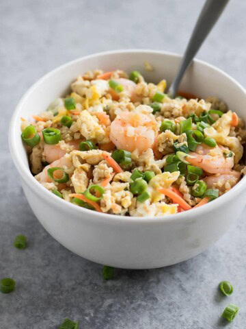 Forget takeout. Make Cauliflower Shrimp Fried Rice at home using riced cauliflower, carrots, peas, onions, garlic, and coconut aminos in just 15 minutes!