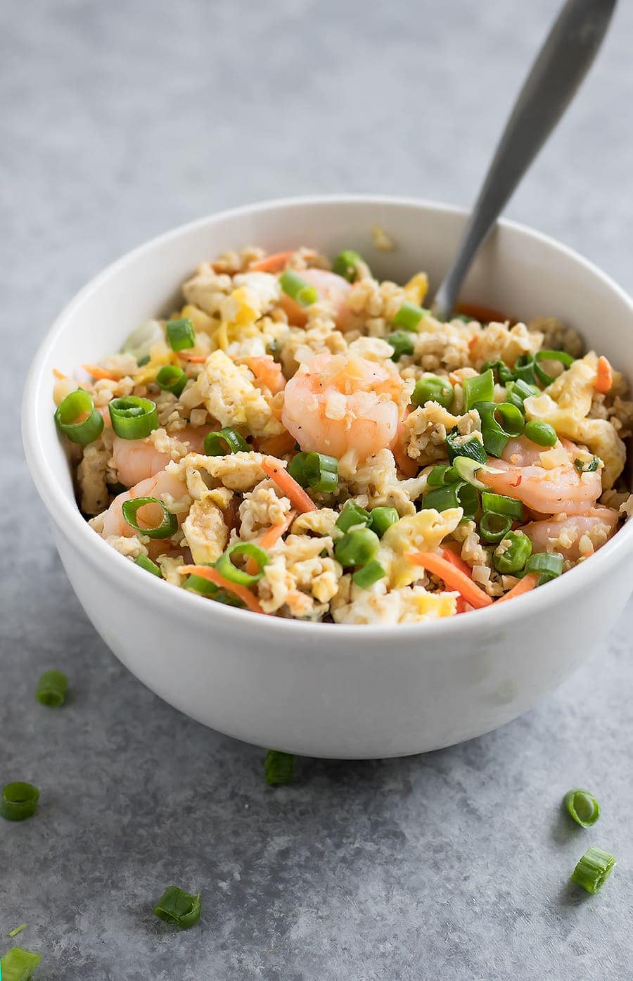 Forget takeout. Make Cauliflower Shrimp Fried Rice at home using riced cauliflower, carrots, peas, onions, garlic, and coconut aminos in just 15 minutes!