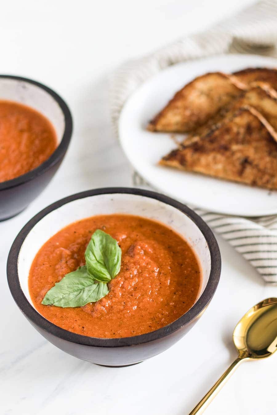 A deliciously simple homemade roasted tomato basil soup that you can enjoy all year round with a melty grilled cheese made with Irish whiskey butter!