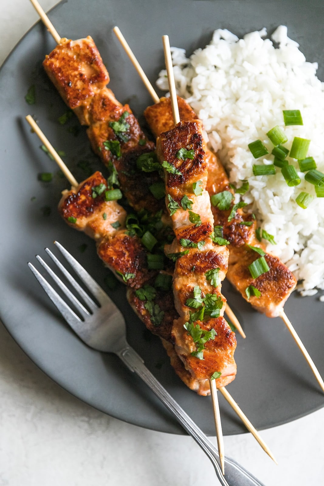 Salmon marinated in honey, garlic, lime, and and cooked on skewers for 10 minutes in a cast iron skillet. An simple yet gourmet weeknight meal!