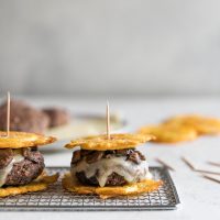 Flavorful black bean burgers topped with melted Swiss cheese and sautéed mushrooms with two twice fried plantains as buns. A delicious Cuban twist on a veggie burger!