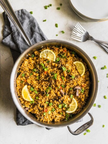 A quick and easy vegetarian paella made with brown rice, garbanzo beans, mushrooms, red peppers, and peas. Perfect weeknight meal!