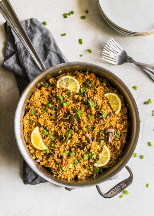 A quick and easy vegetarian paella made with brown rice, garbanzo beans, mushrooms, red peppers, and peas. Perfect weeknight meal!