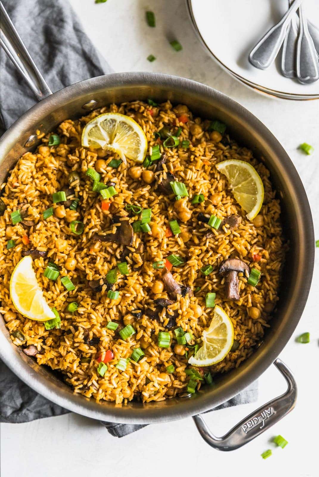 A quick and easy vegetarian paella made with brown rice, garbanzo beans, mushrooms, red peppers, and peas. Perfect weeknight meal!