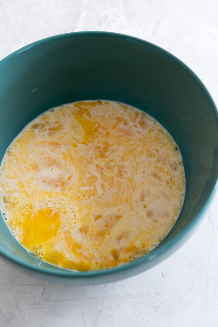 Creamy scrambled eggs in blue bowl, delicious breakfast idea, high-quality food photography.