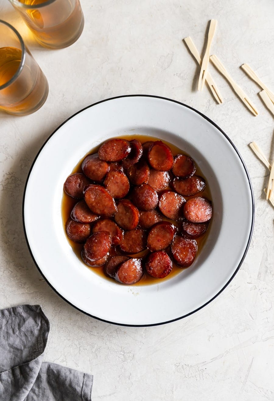 sliced kielbasa sausage caramelized with coke and brown sugar on a white plate