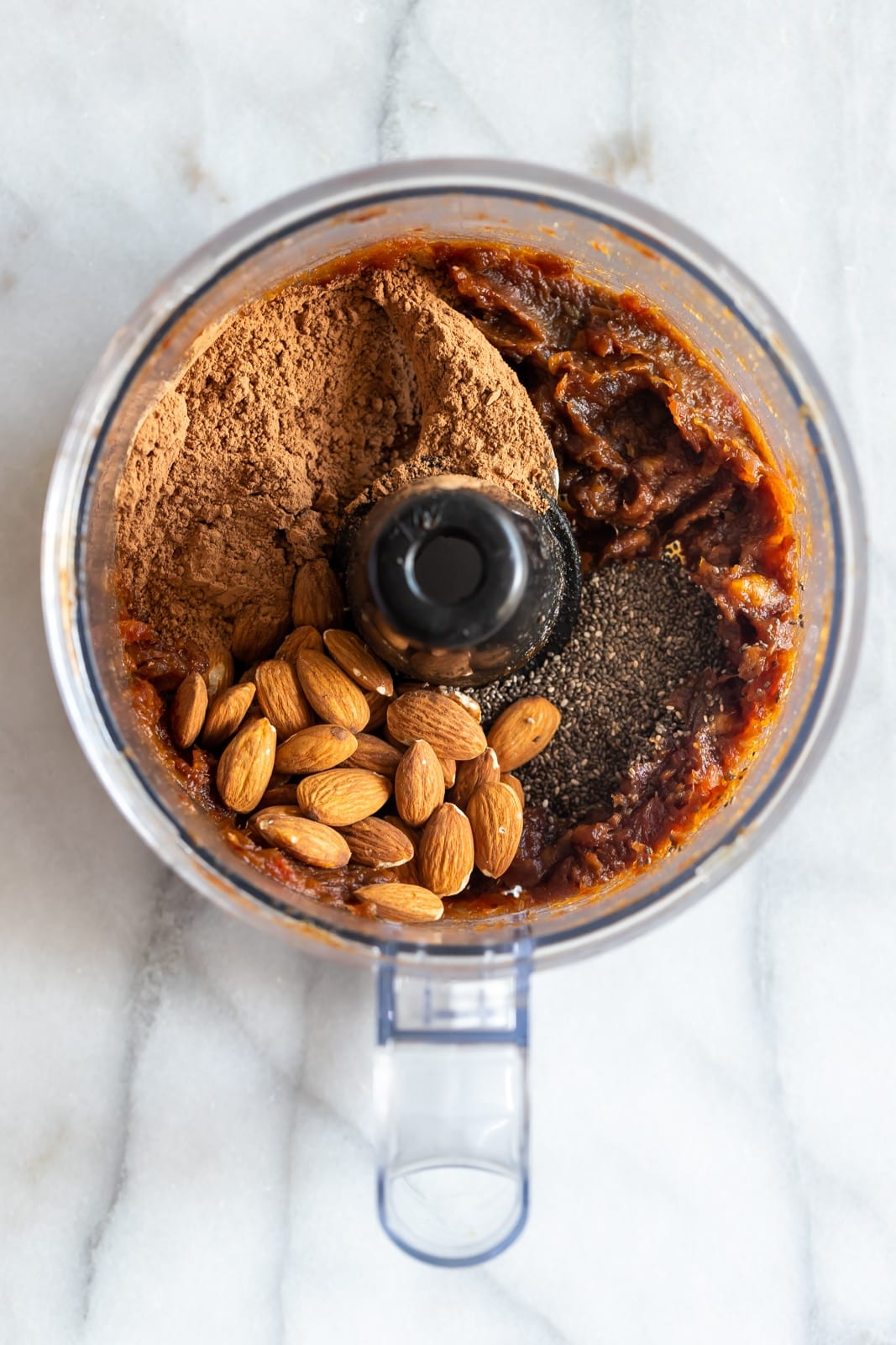 Chocolate energy bite ingredients combined in a food processor