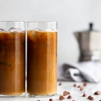 A frothy dairy-free iced cafe con leche (milk with coffee drink) made with sweetened Cuban coffee, chocolate chips, hazelnut creamer, and almond milk.