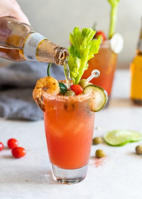 A refreshing beer cocktail made with Mexican beer, lime juice, spices, tomato juice, and smoky sauces, served in chilled, chili salt rimmed glasses.