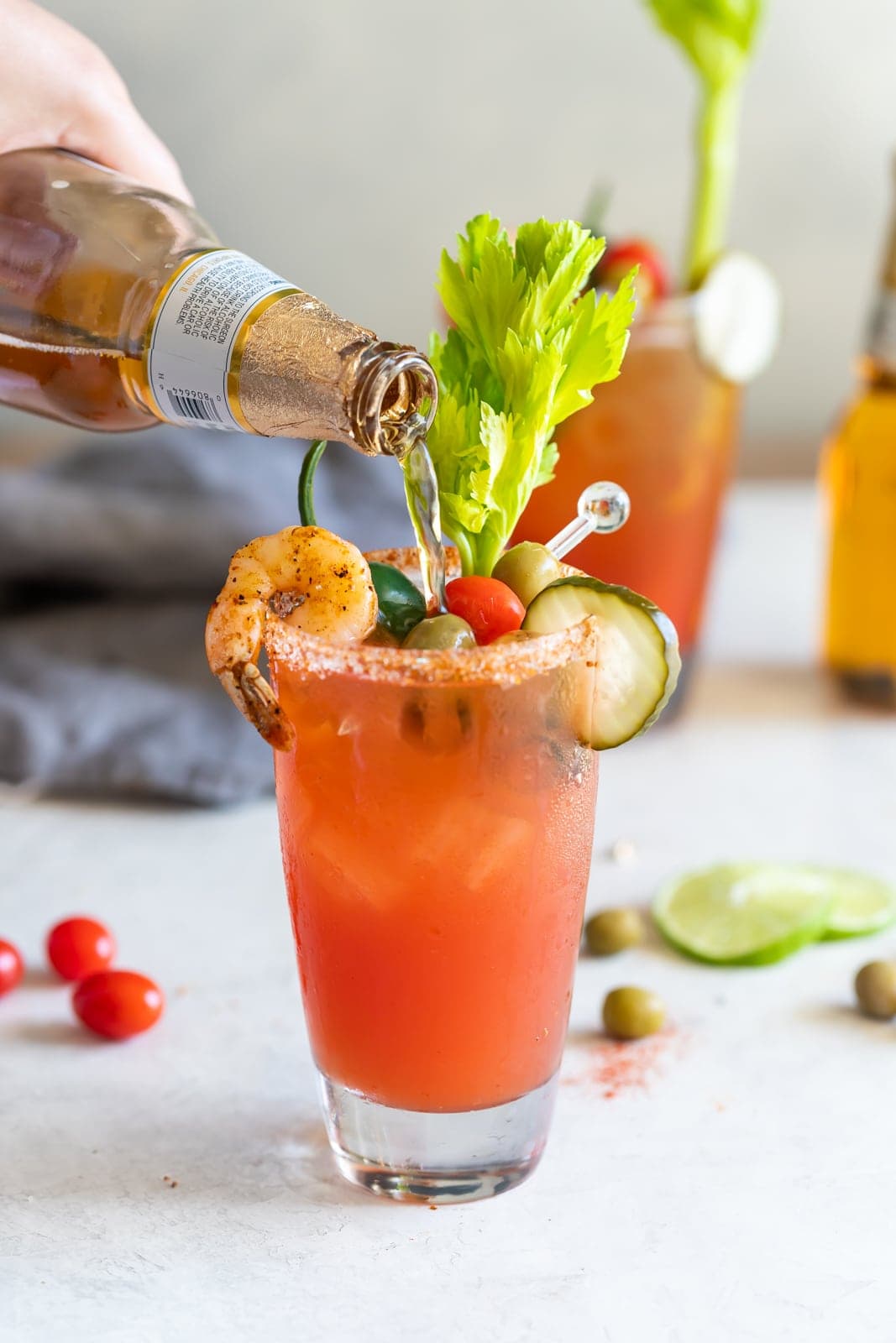  Un cocktail de bière rafraîchissant à base de bière mexicaine, de jus de citron vert, d'épices, de jus de tomate et de sauces fumées, servi dans des verres glacés cerclés de sel de chili.