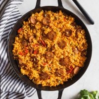 large skillet with chicken sausage and yellow rice