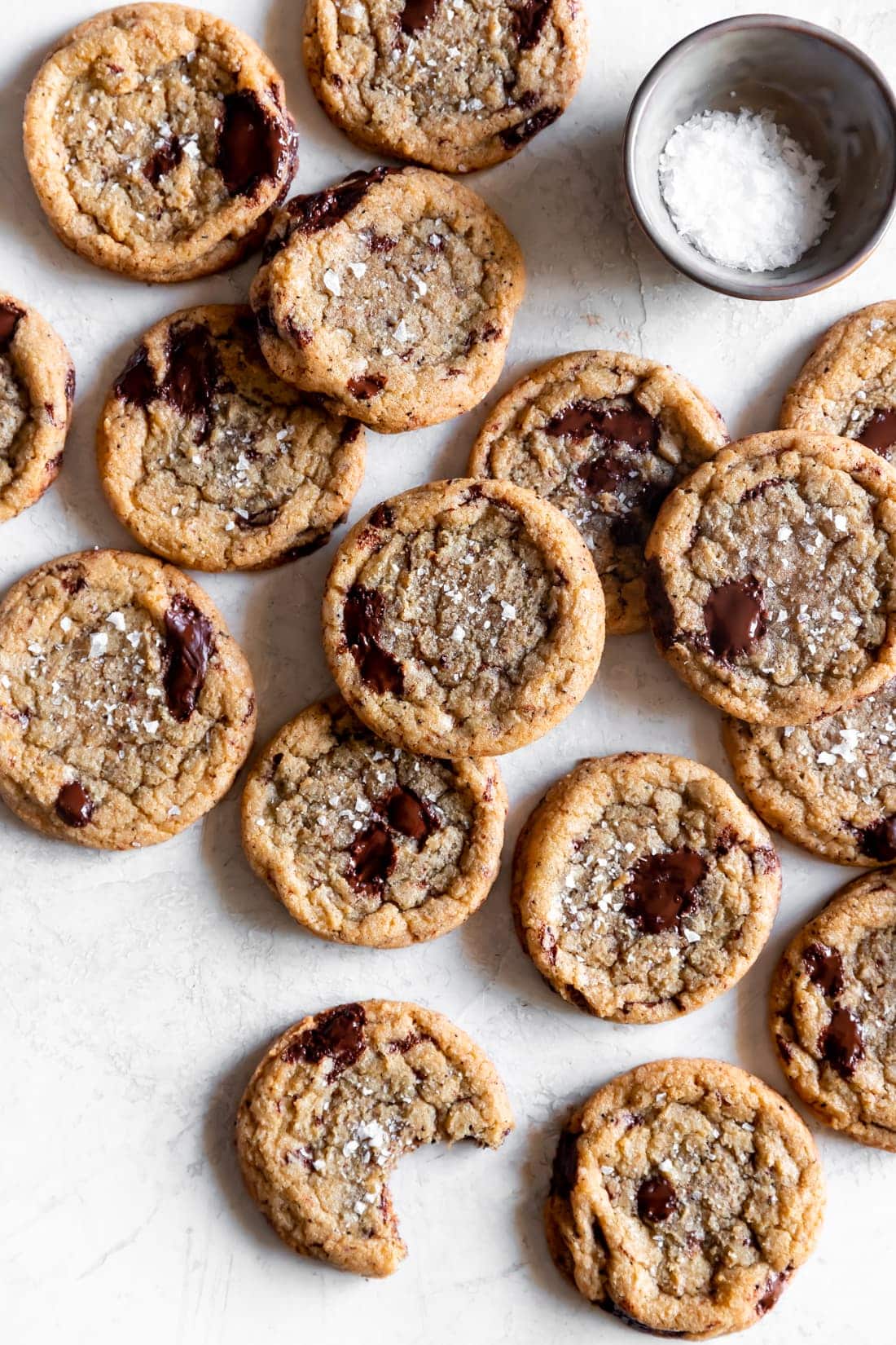 chewy brown butter chocolate chip cookies with sea salt on a white background