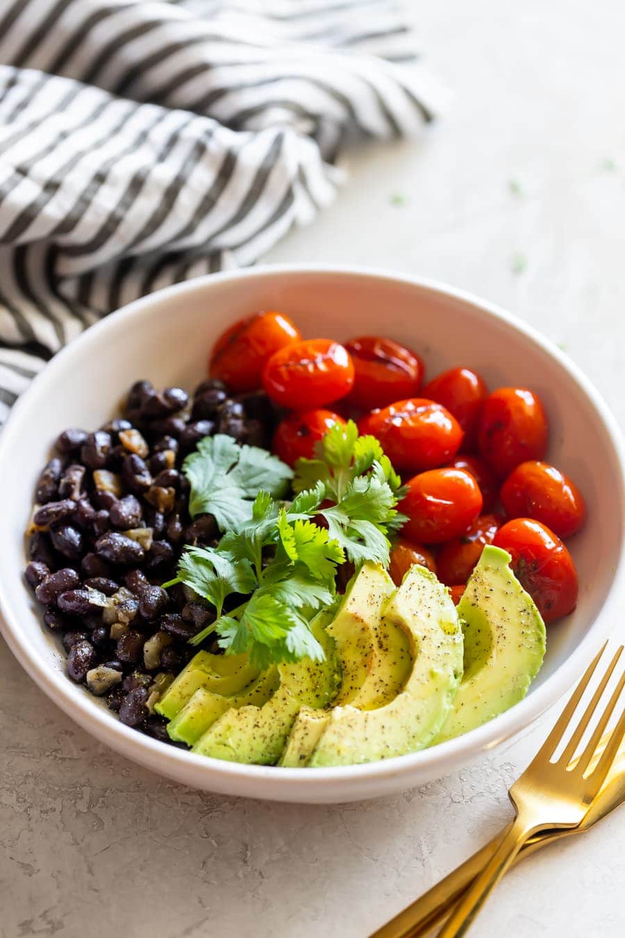 charred tomato salad bowl with sautÃ©ed black beans and sliced avocado