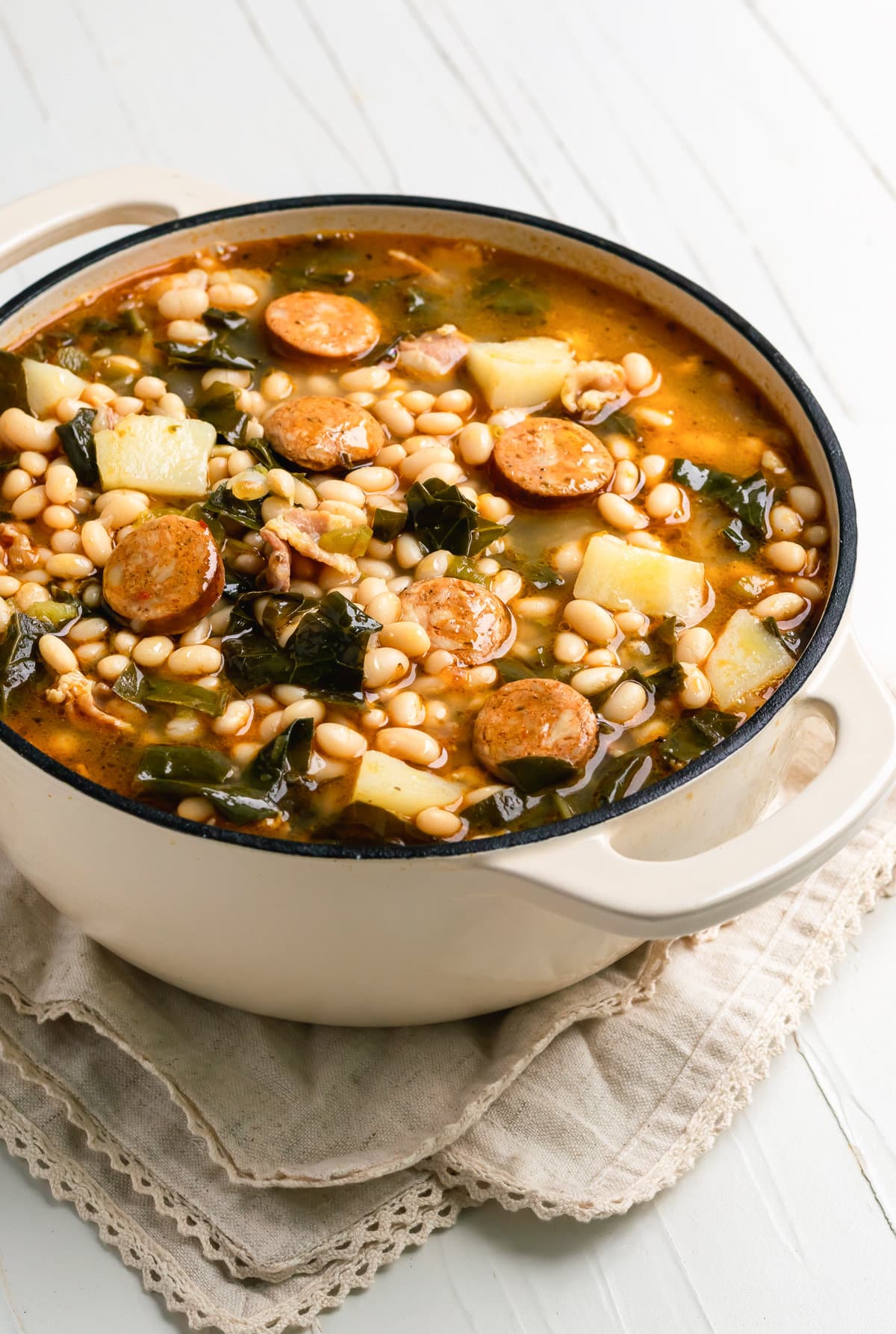caldo gallego with white beans, chorizo, greens, potatoes in chicken broth in a Dutch oven