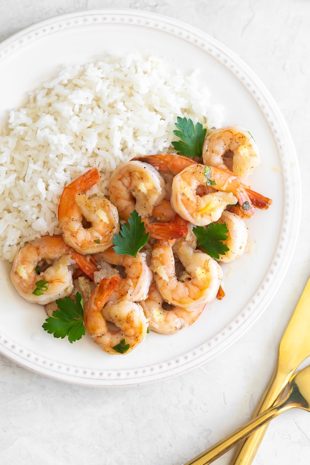 shrimp in garlic sauce plated with white rice and chopped parsley