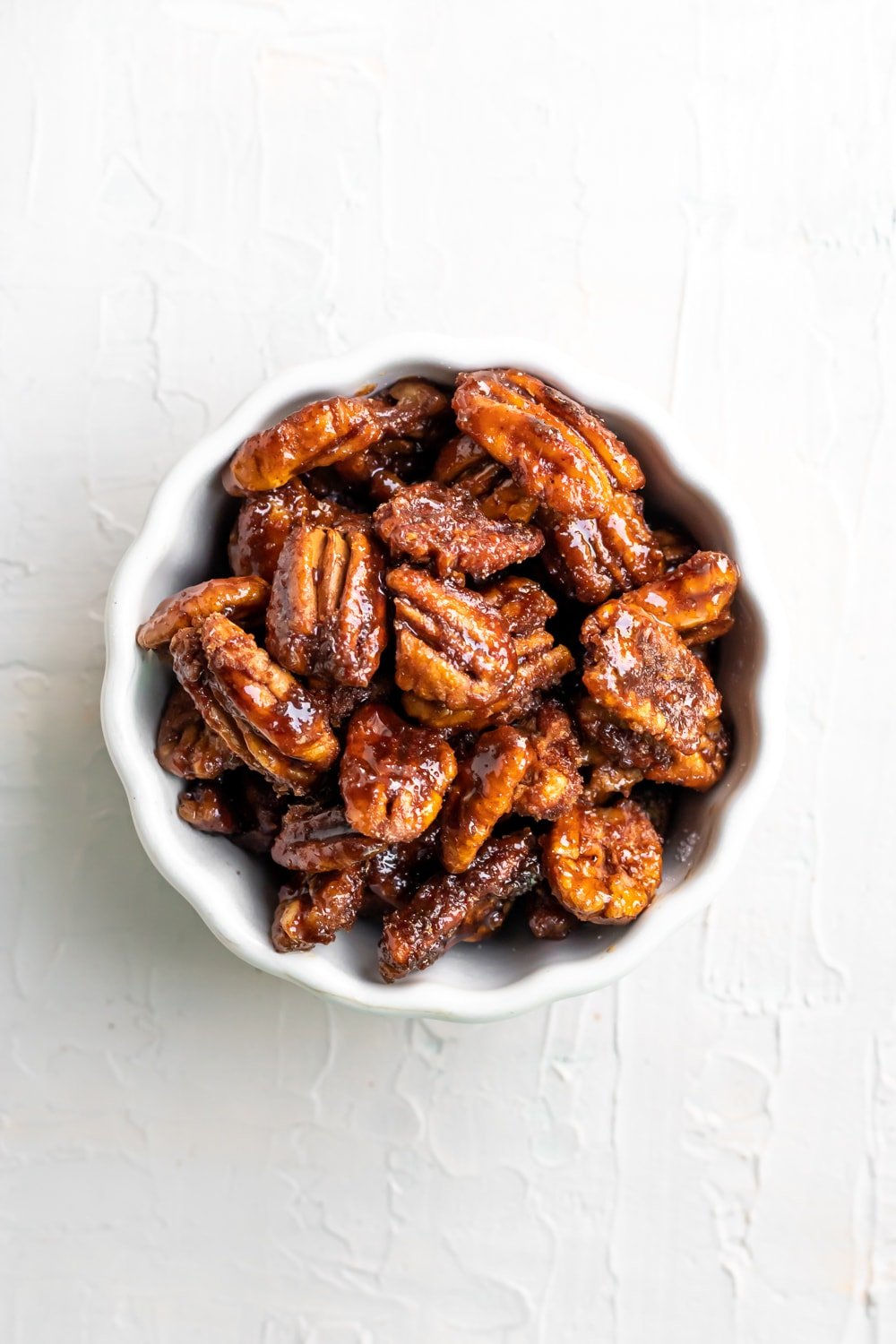candied pecans in a bowl on a white table