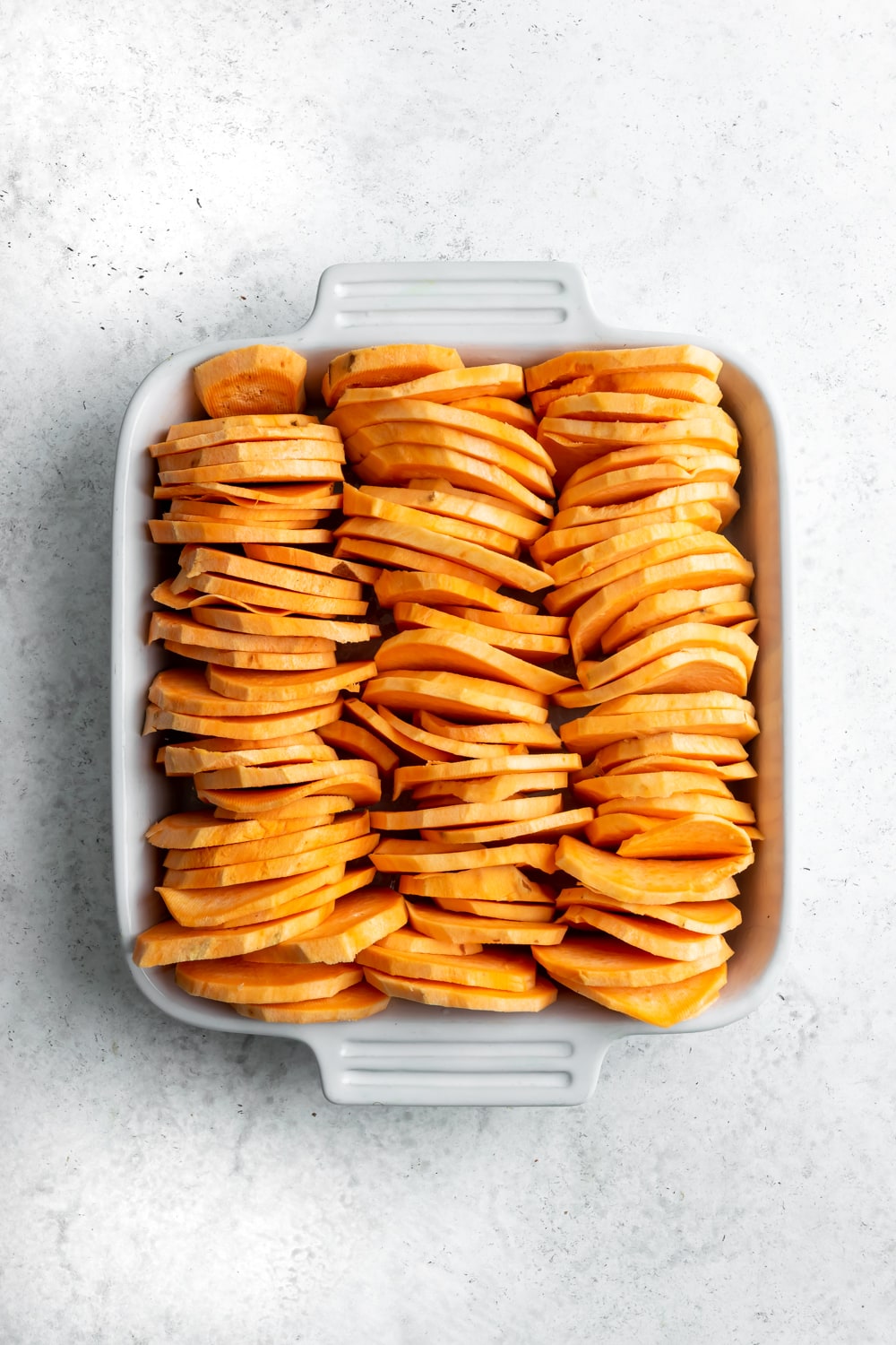 sliced sweet potatoes in a baking dish
