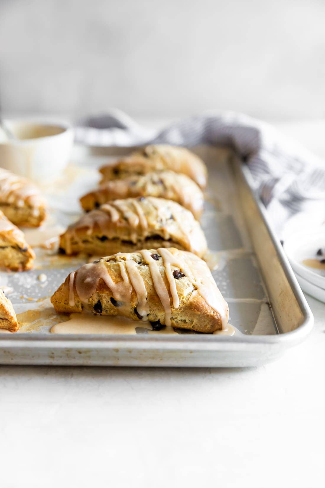 baked chai chocolate chip scone with espresso glaze on a baking sheet
