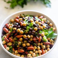 A plate with three bean salad tossed in chimichurri sauce
