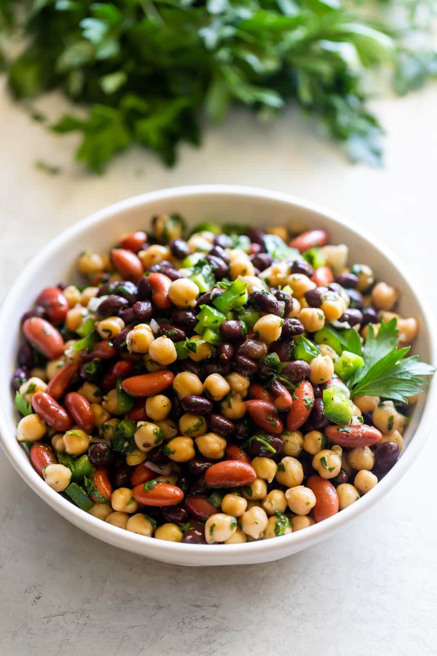 A plate with three bean salad tossed in chimichurri sauce