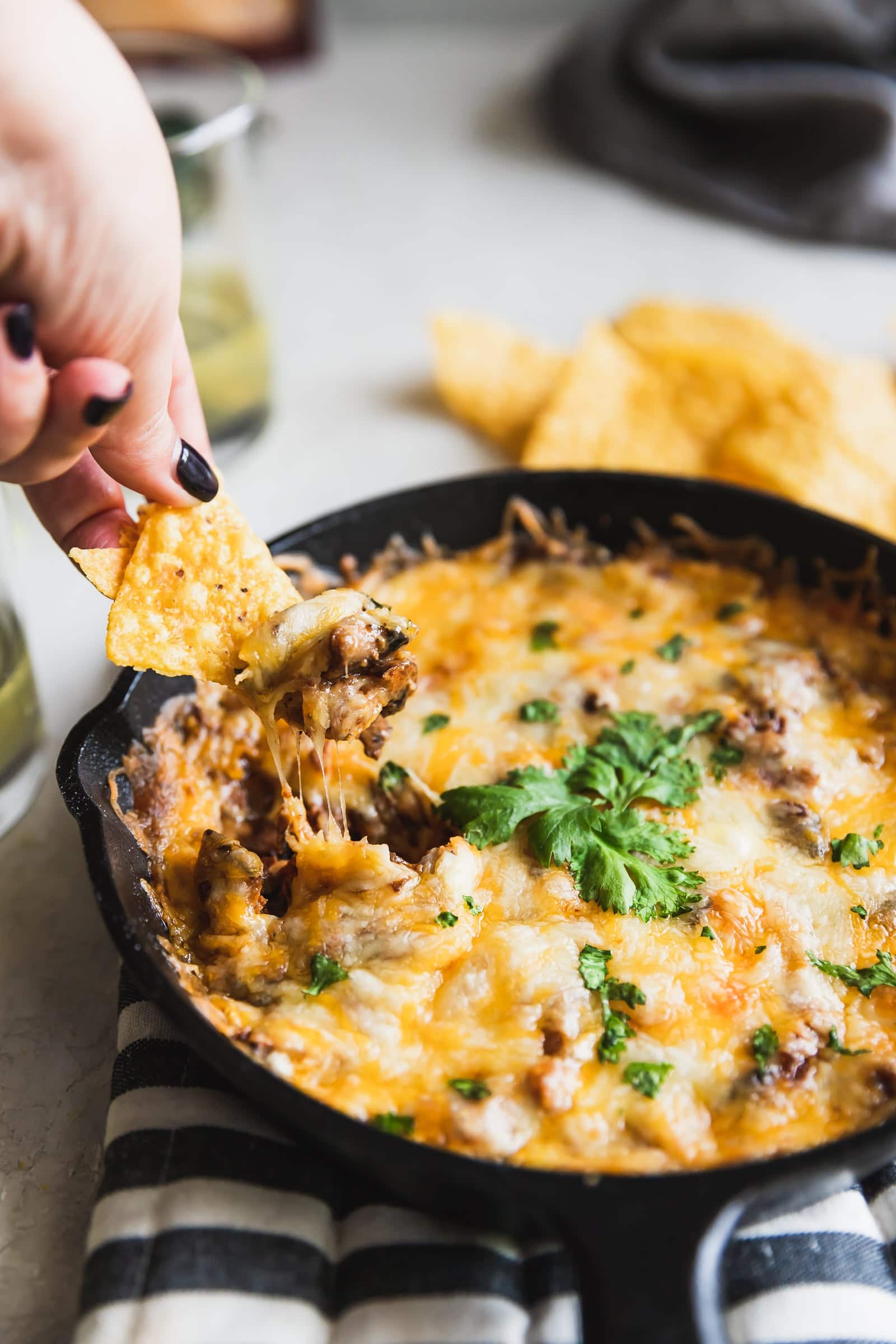 tortilla chip with a cheese pull from queso fundido