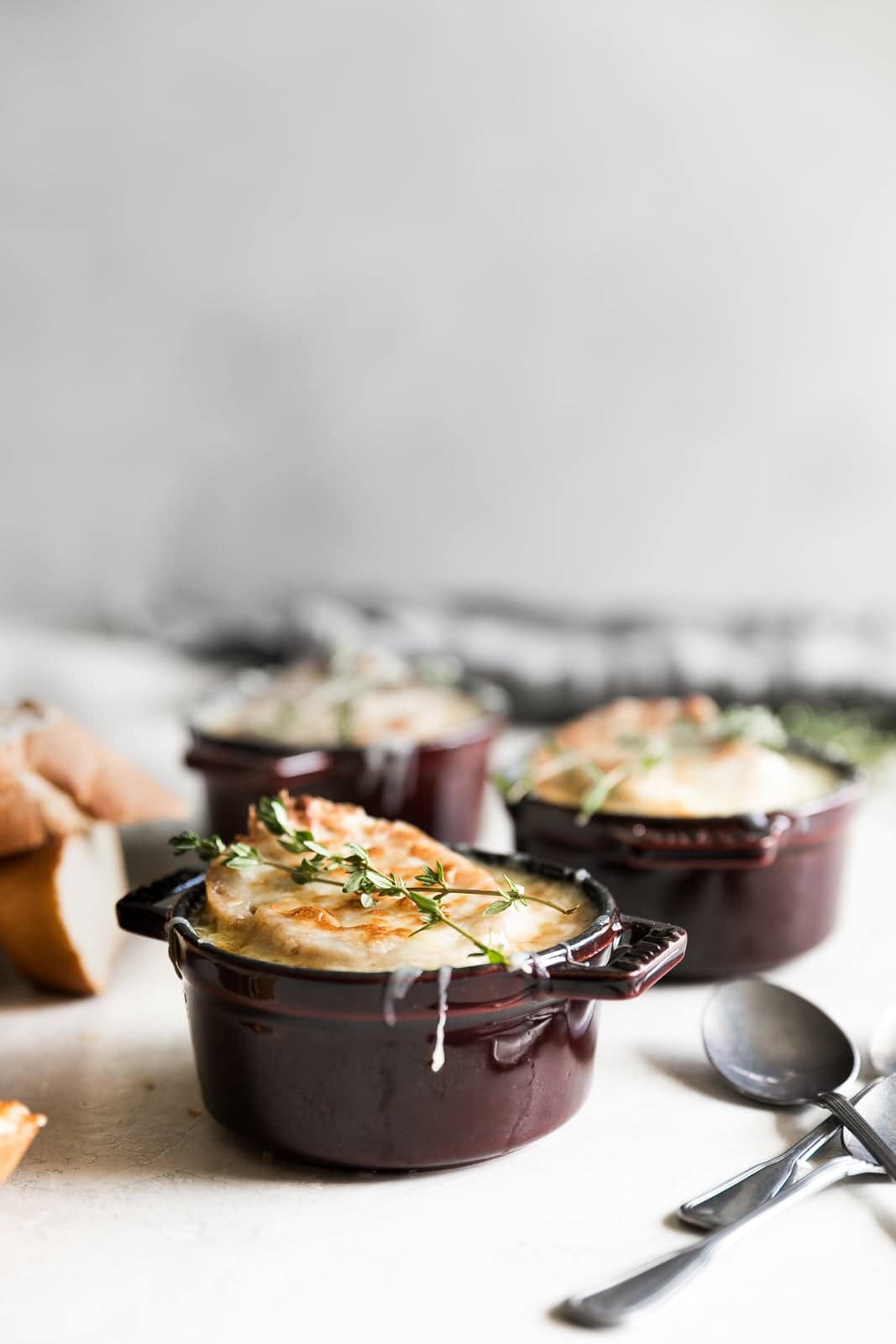onion soup in cocotte and crusty bread with melty cheese
