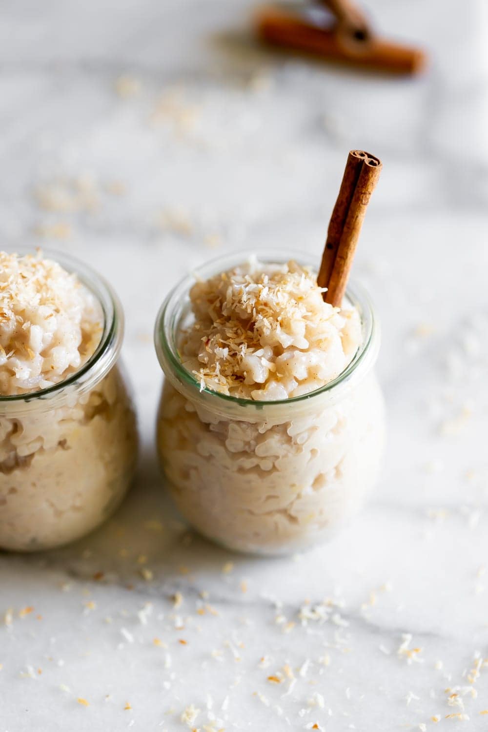 arroz con leche de coco in weck jars with coconut flakes on a marble slab