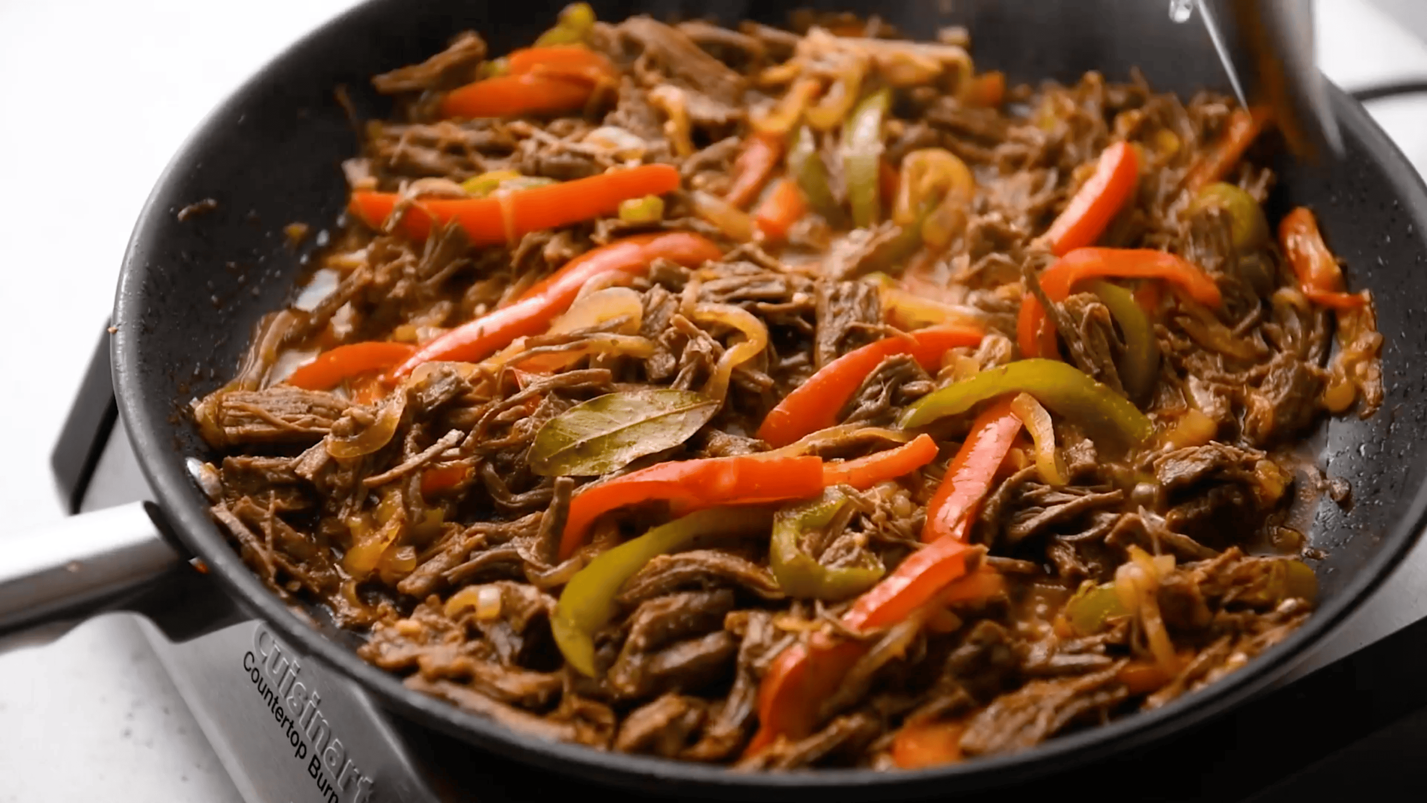 ropa vieja being cooked in a skillet