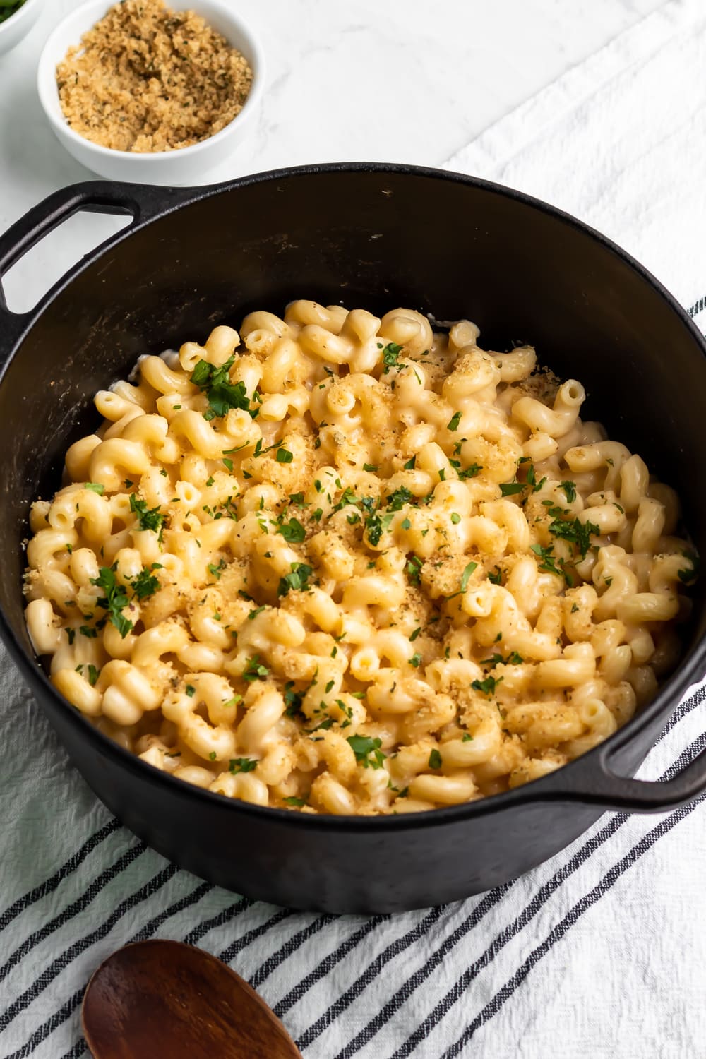 creamy mac and cheese cooked in a pot with lots of cheese and fresh parsley