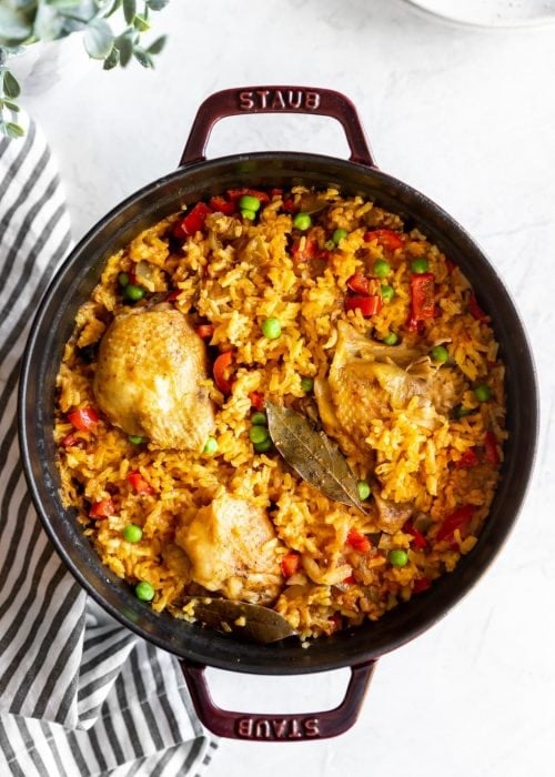 Staub dutch oven with cooked Cuban yellow rice with chicken (arroz con pollo)