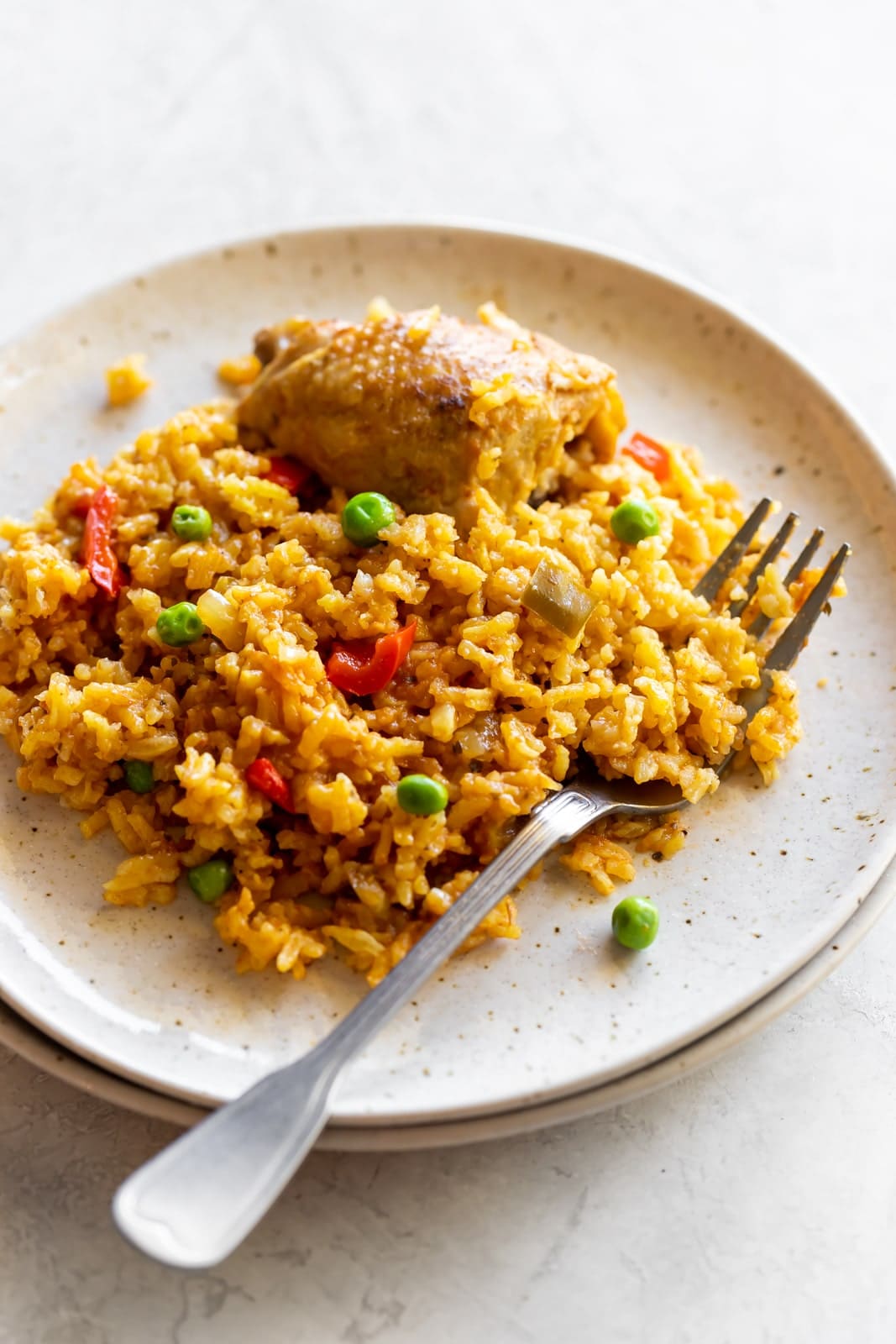 The best comfort food - arroz con pollo! Classic and authentic Cuban-style rice with chicken made with in one-pot with spices, tomato sauce, flavorful chicken thighs and fluffy yellow rice.