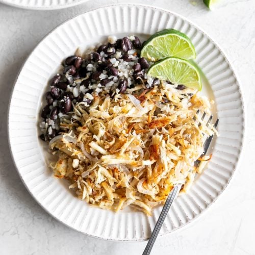 cuban shredded chicken with black beans and rice on a white plate