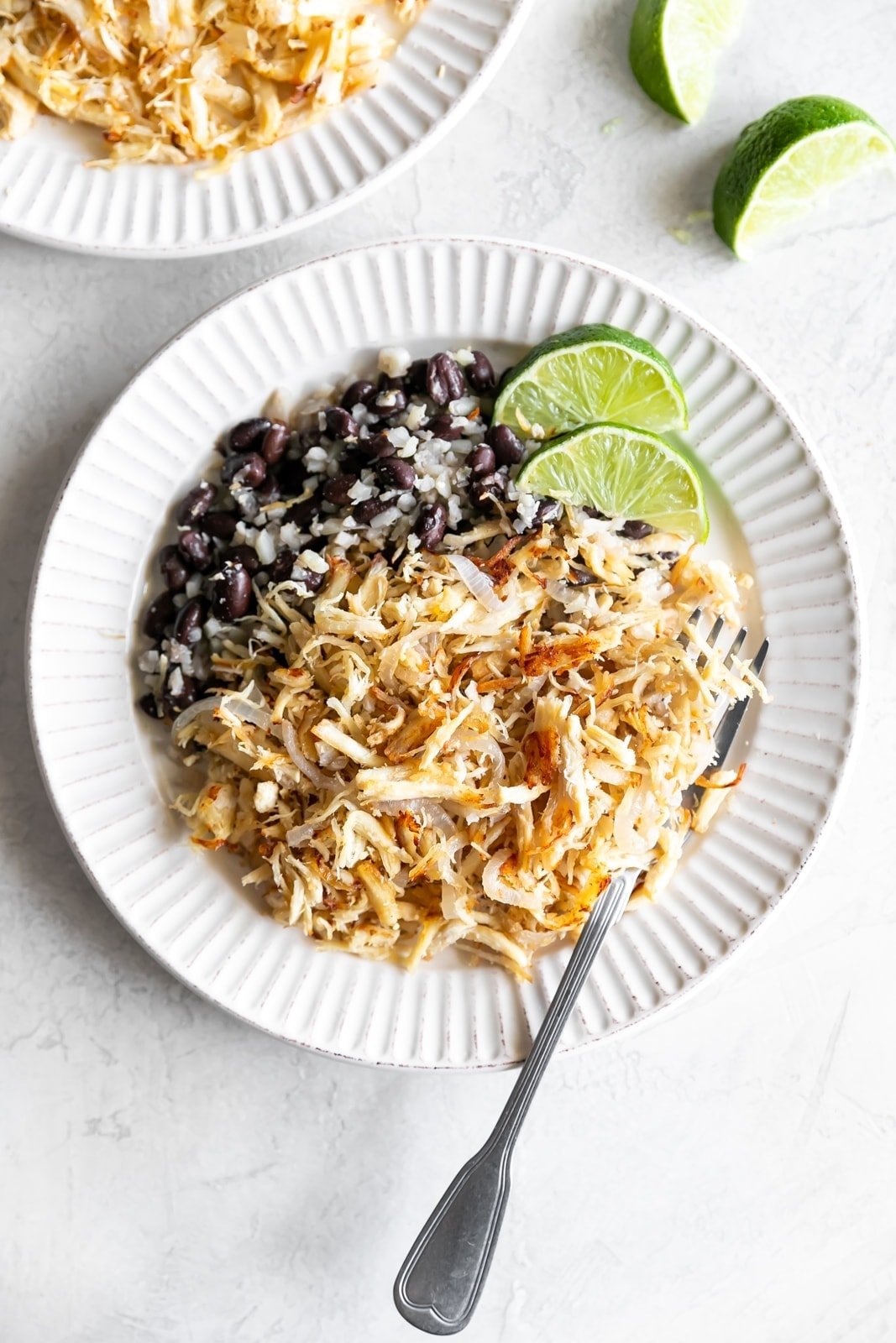 cuban shredded chicken with black beans and rice on a white plate