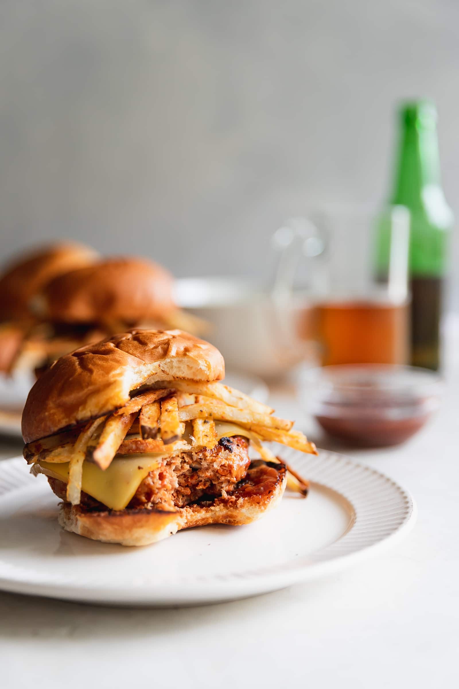 A Cuban-inspired burger made with ground turkey, chorizo, chopped onions, spices, melted gruyere, homemade shoestring potatoes, and guava BBQ sauce served on toasted hamburger buns.