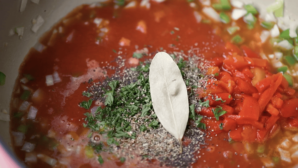 Tomato sauce, spices, and aromatics to continue cooking