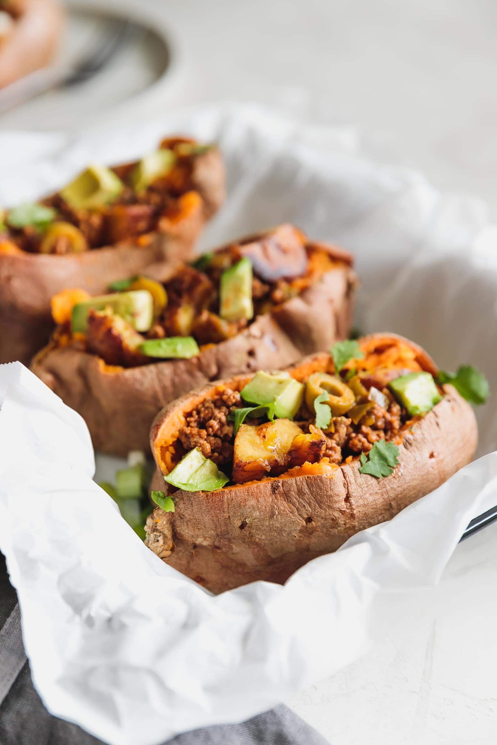 Sweet potatoes stuffed with Cuban-style lean ground beef, chopped sweet plantains, and avocado. A flavorful, easy-to-make 35-minute meal for busy weeknights!